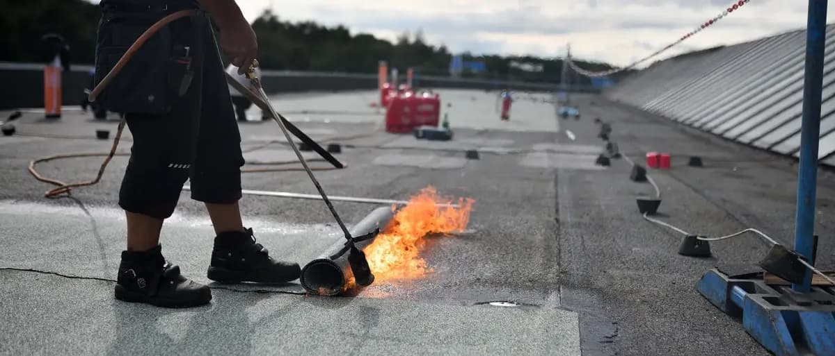 Commercial roof repair contractor working on business building