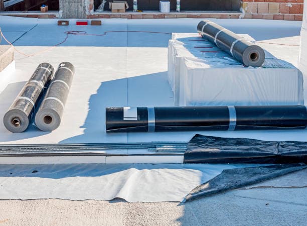 Professional commercial roof repair technician working on damaged commercial building