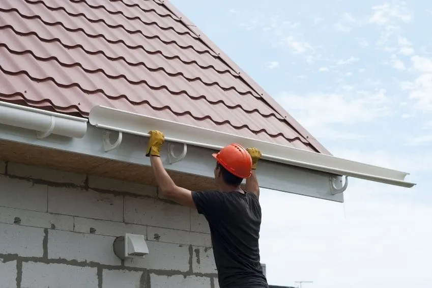 Professional gutter repair team working on residential home