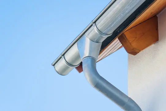 Professional seamless gutter installation on residential home